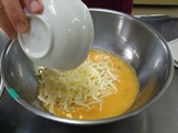 溶きほぐした卵にチーズを加える写真