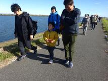 健康ウォーキング大会で利根川沿いを歩く参加者の写真