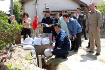 民主党　岡田幹事長の視察に市内の現状を説明3