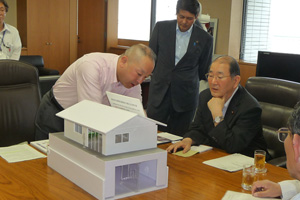 細川大臣に、家屋の模型を使って、住宅における液状化被害の深刻な実態を熱く説明する宇井市長